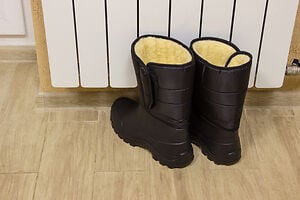 winter boots by a white radiator