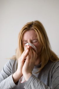 woman sneezing with a cold