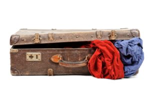 Old suitcase with blankets inside isolated on white background