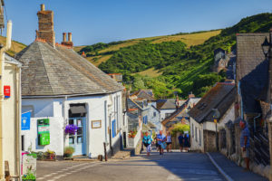 29 June 2018: Port Isaac, Cornwall, UK - Group of people walking in Fore Street during the summer heatwave.